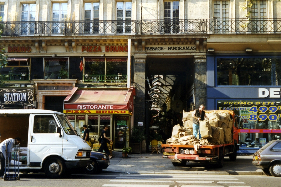Fast übersehen vor lauter Lieferwagen. Alltag vor dem Eingang zur Passage Panoramas, Paris